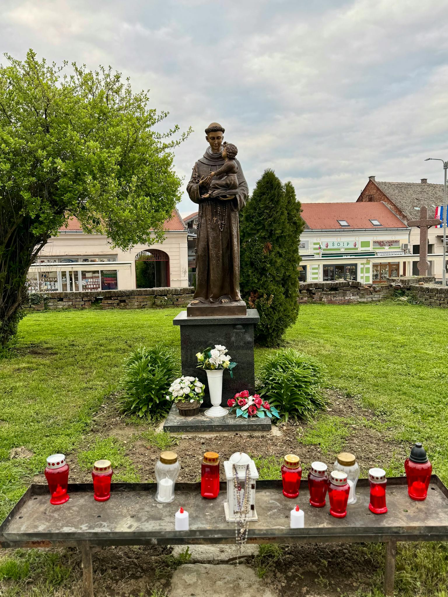 A statue of Saint Anthony holding a child, located in a park in Našice, Croatia.